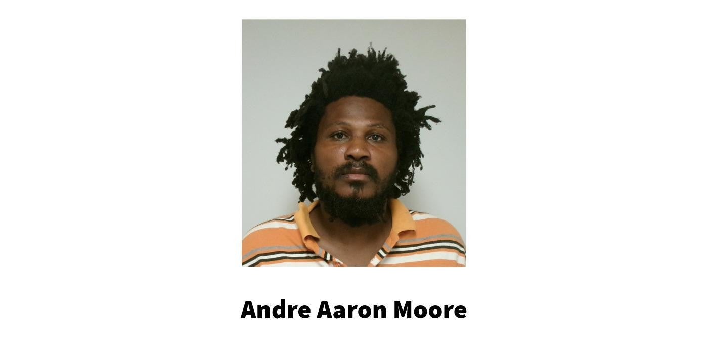Booking photo of a man that is wearing an multicolor orange stripped polo shirt above the name Andre Aaron Moore.